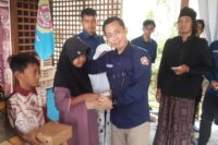 Penasehat Karang Taruna Winduaji Bagus Handoko menyerahkan santunan kepada yatim piatu, Minggu 1 Desember 2024. (Portal Pantura/Yudhi Prasetyo)