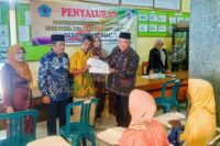 Kepala Desa Kutamendala H. Fathuri, S.Ag. menyerahkan BLT DD tahap 1 2025 secara simbolis didampingi Sekcam Tonjong Widodo dan Kasi PMD Yekti Utaminingsih. Foto: Portal Pantura/Yudhi Prasetyo.