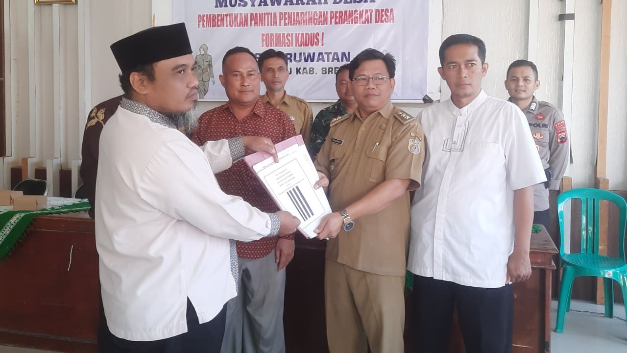 Kades Pruwatan Rasiman menyerahkan SK pengangkatan Rohiman sebagai ketua panitia penjaringan perangkat Desa Pruwatan. Foto: Portal Pantura/ Yudhi Prasetyo.