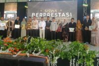 Kepala SMK Maarif NU Paguyangan Mardiyanto S.Ag foto bersama siswa-siswi berprestasi yang didampingi orangtuanya.