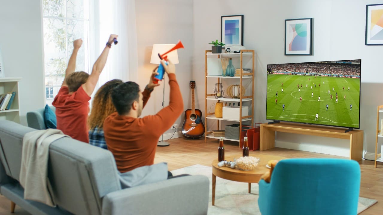Keluarga sedang menyaksikan pertandingan bola dengan menggunakan AQUOS XLED HU8500.