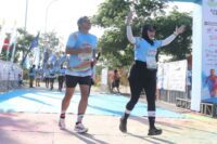 Dua peserta Heritage Color Fun Run 2025 di rest area Bajaratma, Brebes, Minggu 20 Juli 2025 memasuki finish dan berselebrasi.