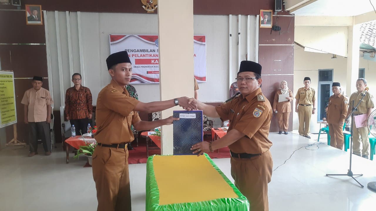 Kepala Desa Pruwatan Rasman SH menyerahkan SK Pelantikan Agus Sadewo sebagai Kadus I. Foto: Portal Pantura/Yudhi Prasetyo.
