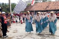 Kepala Desa Langkap Mustholih melepas peserta gerak jalan dalam rangka HUT ke-80 RI tingkan desanya. Foto: Portal Pantura/Imam Muzaky.