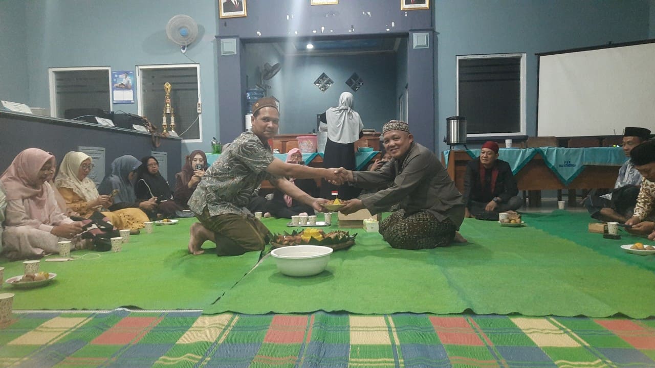 Ketua Panitia HUT ke-80 RI tingkat Desa Kutamendala menyerahkan potongan tumpeng kepada Kepala Desa Kutamendala H. Fathuri SAg. Foto: Portal Pantura/Yudhi Prasetyo.