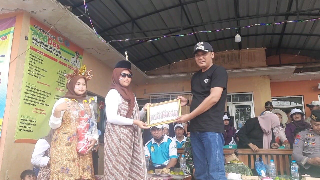 Kepala Desa Kalijurang Edi Riyanto SH menerima cinderamata dari peserta karnaval HUT ke-80 tingkat desa setempat. Foto: Portal Pantura/Yudhi Prasetyo.