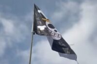 Bendera bajak laut One Piece berkibar di bawah langit biru. Fenomena ini viral jelang HUT ke-80 RI, jadi simbol protes warga atas ketimpangan dan ketidakadilan sosial. Foto: tangkapan layar TikTok.