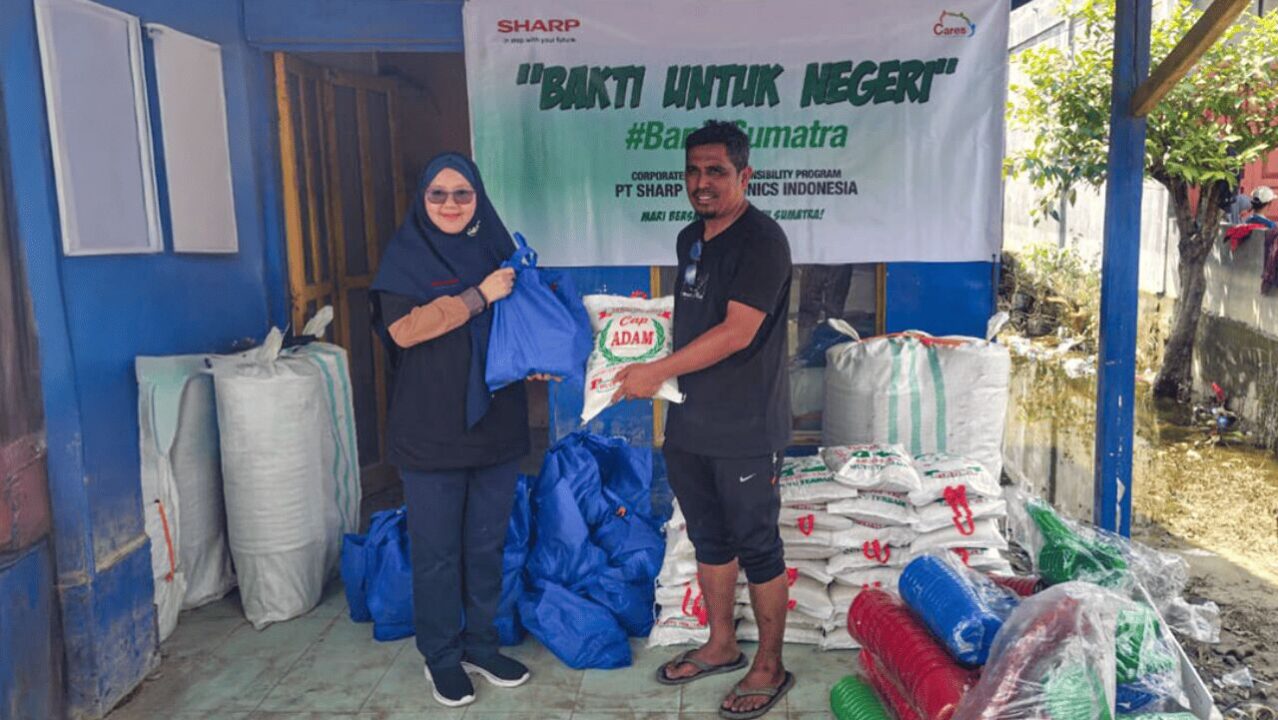 Lise Tiasanty, S.Pd., MM., Customer Satisfaction Head Division menyerahkan donasi kepada korban banjir di  desa Parupuk di Kabupaten Langkat, Sumatera Utara. Foto: dok. Sharp Indonesia.