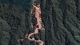 Citra Google Maps menampilkan bukaan lahan sepanjang tiga kilometer di lereng barat daya Gunung Slamet, Kecamatan Cilongok, Kabupaten Banyumas, yang sempat viral di media sosial. Kementerian ESDM mengonfirmasi bahwa lahan tersebut merupakan bekas aktivitas eksplorasi panas bumi PT Sejahtera Alam Energi pada 2017-2018 dan kini sudah tertutup vegetasi. Foto: Tangkapan layar Google Maps