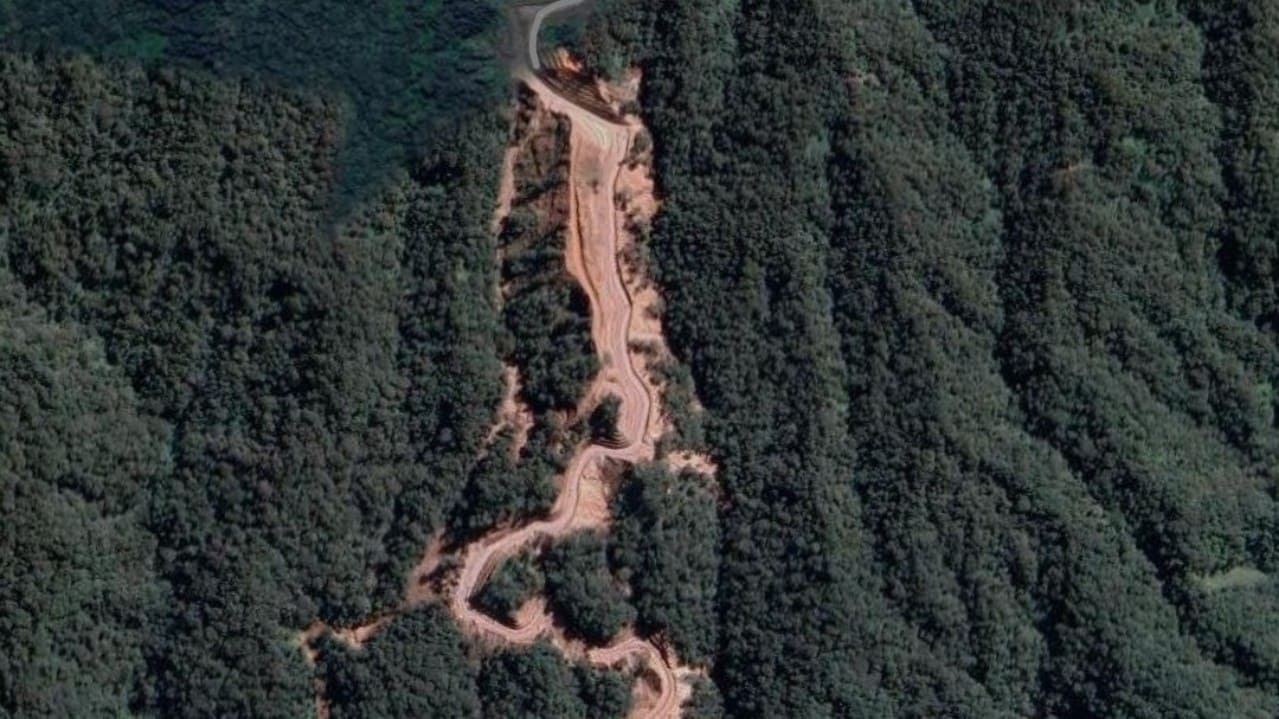 Citra Google Maps menampilkan bukaan lahan sepanjang tiga kilometer di lereng barat daya Gunung Slamet, Kecamatan Cilongok, Kabupaten Banyumas, yang sempat viral di media sosial. Kementerian ESDM mengonfirmasi bahwa lahan tersebut merupakan bekas aktivitas eksplorasi panas bumi PT Sejahtera Alam Energi pada 2017-2018 dan kini sudah tertutup vegetasi. Foto: Tangkapan layar Google Maps