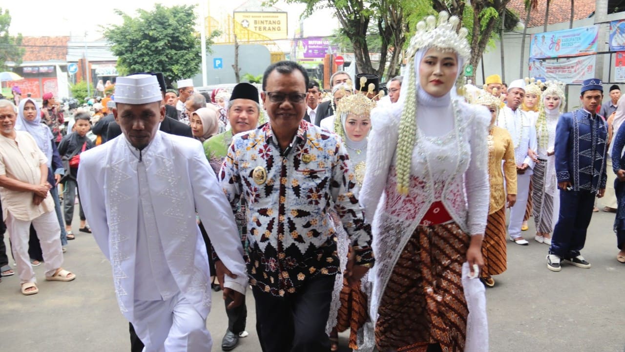 Kebahagiaan terpancar dari pasangan pengantin saat berfoto bersama Wakil Bupati Brebes Wurja. Mereka adalah bagian dari 24 pasangan yang menikah gratis lengkap dengan rias pengantin dan dokumen kependudukan di MPP Brebes, Kamis (15/1/2025). (Foto: Humas Pemkab Brebes)