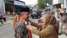 Kades Purwodadi, Kecamatan Tonjong, Brebes mengalungkan slempang pada anggota DPRD Jateng Iskak dalam acara reses di balai desa Purwodadi, Senin (22/6/2026). (Foto: Portal Pantura/Yudhi Prasetyo)