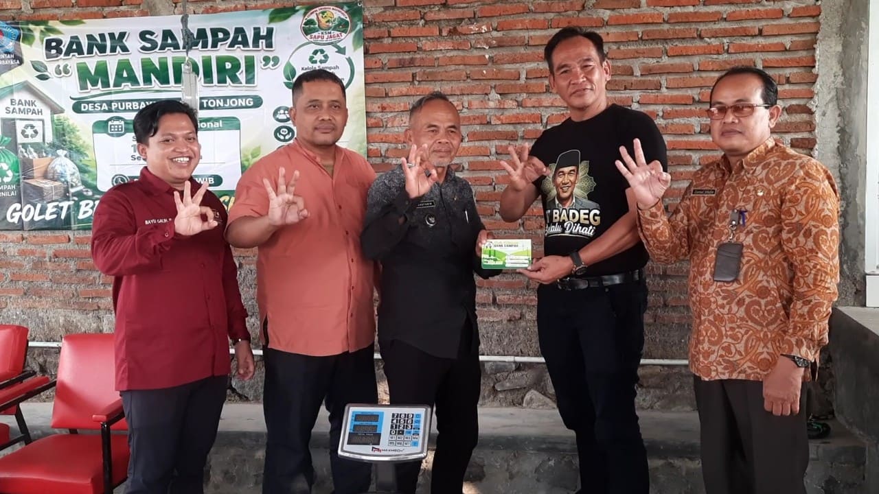 Kepala Desa Purbayasa Syaefudin menerima buku tabungan sampah secara simbolis saat peluncuran Bank Sampah Mandiri di Balai Desa Purbayasa, Kamis (16/7/2026) didampingi anggota DPRD Brebes Ade Apriyanto, Sekcam Tonjong Zaenal Arifin dan TLH Kecamatan Tonjong Bayu Galih. (Foto: Portal Pantura/Yudhi)