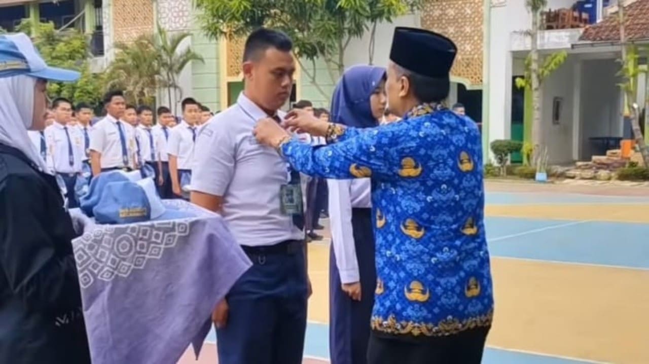 Kepala SMAN 1 Bumiayu, Dr. H. Ihdi Amin, M.Pd., menyematkan kokard kepada perwakilan siswa baru sebagai tanda dimulainya MPLS tahun pelajaran 2026/2027, Senin (13/7/2026). (Foto: Istimewa)