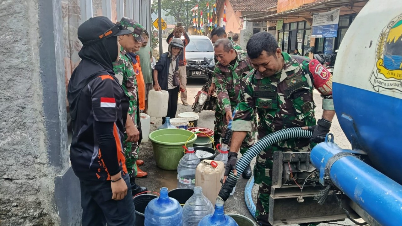 Personel Koramil 11 Paguyangan mendampingi pendistribusian air bersih dari tangki BPBD Bumiayu kepada warga Dusun Cipanas, Desa Kedungoleng, Paguyangan, Brebes, Kamis (6/8/2026).