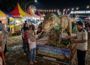 Iluatrasi Pengunjung menikmati sensasi berinteraksi dengan robot dinosaurus animatronik yang bergerak dan bersuara (Foto: Gemini/Generate AI)