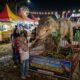 Iluatrasi Pengunjung menikmati sensasi berinteraksi dengan robot dinosaurus animatronik yang bergerak dan bersuara (Foto: Gemini/Generate AI)