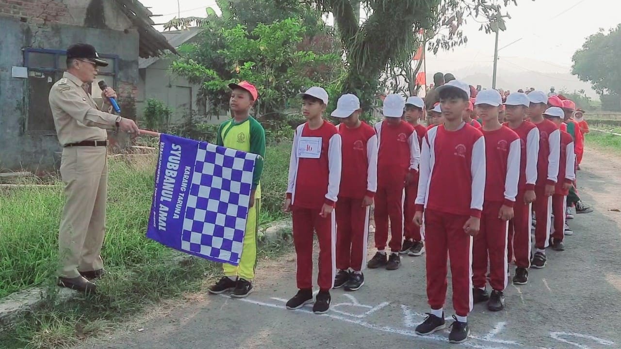 Peserta lomba gerak jalan antusias menampilkan yel-yel terbaik sebelum dilepas oleh Kepala Desa Karangjongkeng di Dukuh Tegalaos, Senin (3/8/2026). (Foto: Portal Pantura/Yudhi)