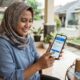 Warga memeriksa status kepesertaan Program Keluarga Harapan dan Bantuan Pangan Non Tunai tahap ketiga melalui situs resmi Kementerian Sosial dari telepon genggam. (Foto: Gemini/Generat AI)