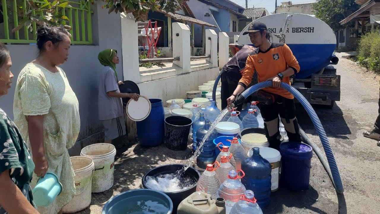 Sejumlah warga Desa Karangjongkeng, Kecamatan Tonjong, Kabupaten Brebes, rela mengantre dan menata wadah air di pinggir jalan demi mendapatkan pasokan air bersih dari BPBD Brebes, Rabu (23/9). (Foto: Portal Pantura/Yudhi P)
