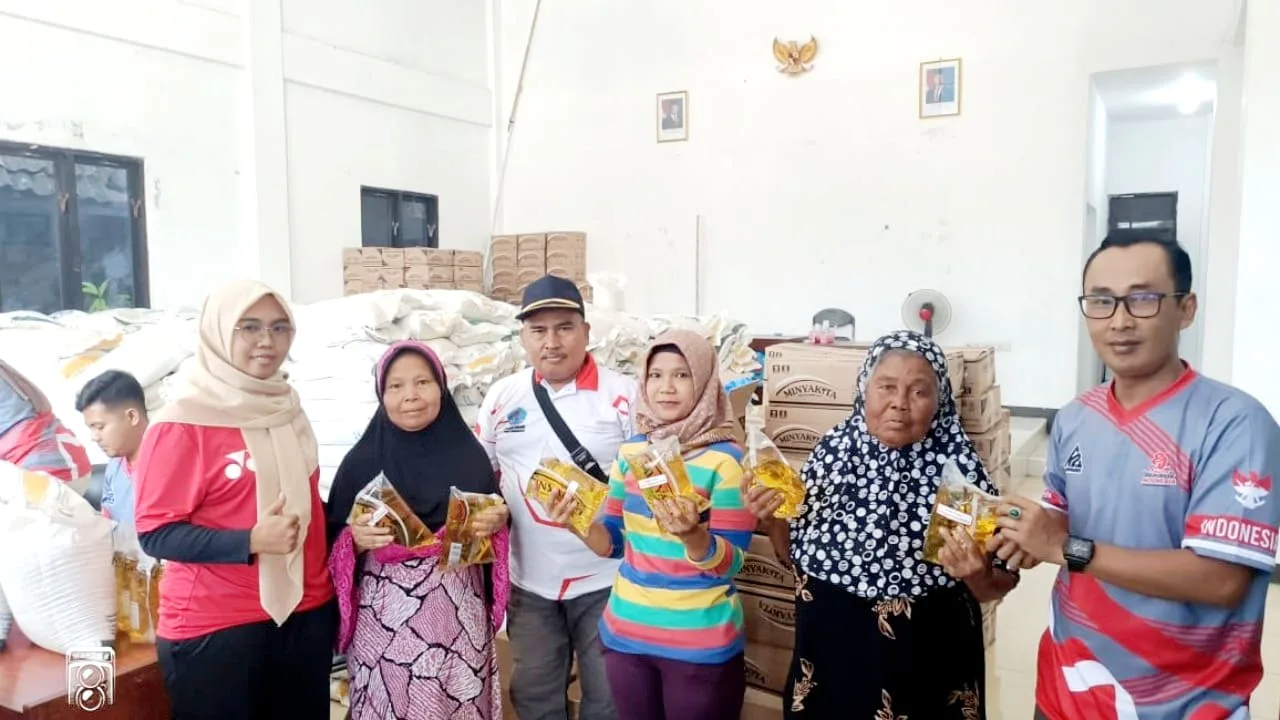 Sekretaris Desa Linggapura Asep Supriyono S.I.P. menyerahkan bantuan sosial sembako kepada salah satu KPM di Aula Balaidesa Linggapura, Kecamatan Tonjong, Kabupaten Brebes, Jumat (5/12/2025). Sebanyak 918 keluarga menerima paket bantuan berupa 20 kg beras dan 4 liter minyak goreng.