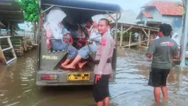 Personel Polsek Losari mengangkut siswa menggunakan mobil patroli menembus genangan banjir rob setinggi 40 cm di Desa Prapag Lor, Kecamatan Losari, Brebes, Rabu (4/12/2025). Program Polri Peduli ini memastikan aktivitas belajar-mengajar tetap berjalan meski cuaca ekstrem. Foto: Humas Polres Brebes.